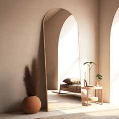 a room with an arch shaped mirror and a vase on the floor next to it