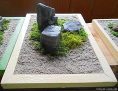 some rocks and grass in a small garden