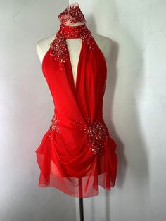 a mannequin wearing a red dress with beading on the neck and shoulders