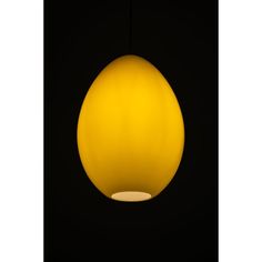 a yellow light hanging from the ceiling in a dark room with black walls and flooring