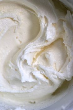 a white bowl filled with whipped cream on top of a table