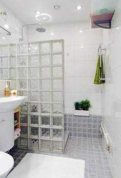 a bathroom with a sink, toilet and shower stall in the middle of the room