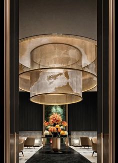 an elegant lobby with large chandeliers and flowers in vases on the floor