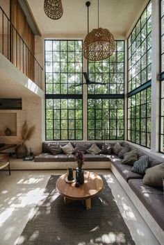 a living room filled with lots of furniture and large windows above it's walls