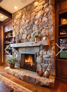 a stone fireplace with potted plants on the mantle