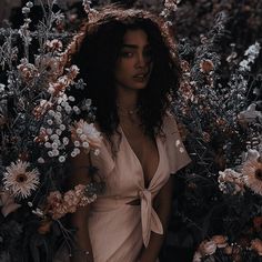 a woman is standing in the middle of flowers