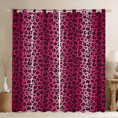 a pink and black leopard print curtain hanging on a wall next to a table with a vase