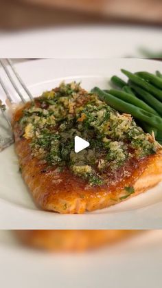 a white plate topped with fish and green beans