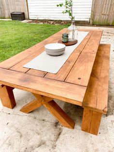 a wooden table sitting in the middle of a yard