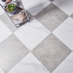 a kitchen floor with white and grey tiles on it, including an open shelf filled with food