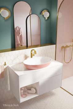 a white sink sitting under a bathroom mirror next to a walk in shower and pink tiled walls