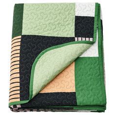 a green and black quilt on top of a blanket