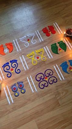 a child is drawing on the floor with colored chalks and candles in front of them