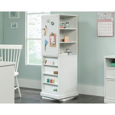 a white bookcase with lots of items on it in a room next to a desk and chair