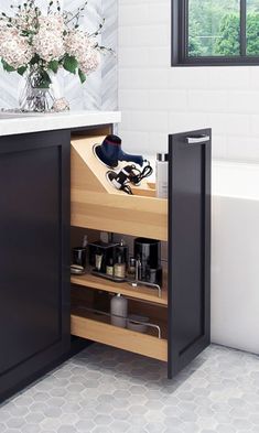 an open cabinet in a bathroom next to a bath tub