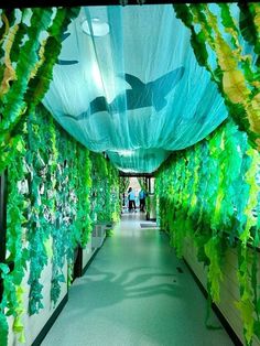 a long hallway with green plants growing on the walls