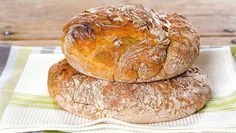 two loaves of bread sitting on top of a towel