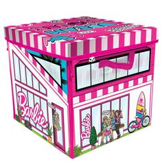 a pink and white striped box with barbie dolls on the front, sitting in front of a building