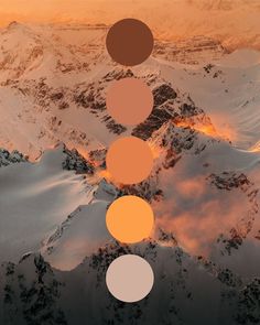 an aerial view of snow covered mountains with orange and yellow circles in the sky over them