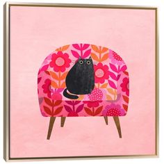 a black cat sitting on top of a pink chair