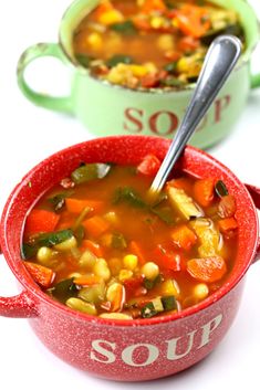 two red bowls filled with soup on top of a white table