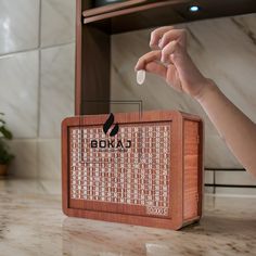 a wooden box with the word boka written on it and a hand reaching out