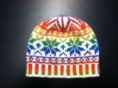 a multicolored knitted beanie hat sitting on top of a black surface