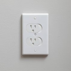 an electrical outlet on the wall is white