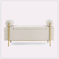 an upholstered bench with two large round cushions on the back and gold legs