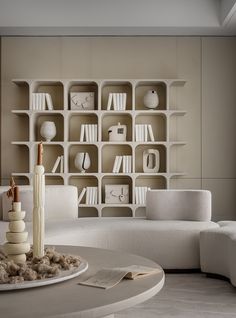 a living room filled with white furniture and bookshelves