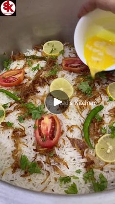 someone is adding lemons to rice in a bowl with tomatoes and peppers on top