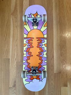 a skateboard with an image of the sun and clouds painted on it's side