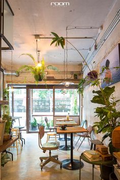 a room filled with lots of tables and chairs next to a wall mounted planter