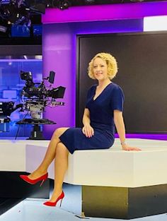 a woman sitting on top of a tv set