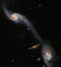 two spiral galaxy like objects in the dark sky