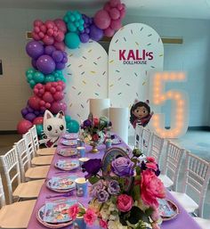 a table set up with balloons and flowers for a children's birthday party at kallis dollhouse