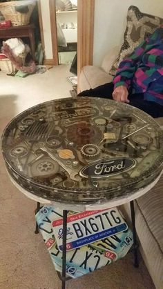 a man sitting on a couch next to a table covered in buttons and other items