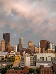 a city skyline with tall buildings under a cloudy sky