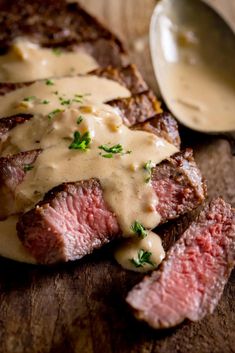 grilled steak with gravy on wooden cutting board