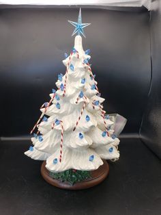 a white ceramic christmas tree with blue and red decorations