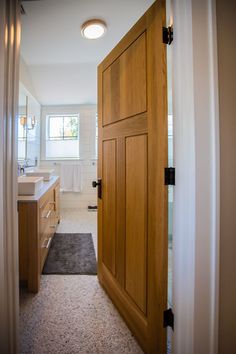 an open wooden door leading to a bathroom