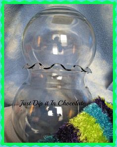 a clear glass vase sitting on top of a blue and green frame with the words just dip it in chocolate