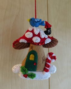 a mushroom ornament hanging on a wooden wall with two birds perched on it