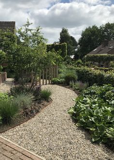 a garden with gravel and plants in the foreground, surrounded by brick pavers