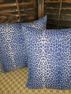 two blue pillows sitting on top of a bed