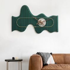 a living room with a brown couch and a green wall clock on it's face