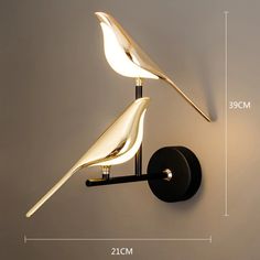 the wall light is designed to look like a bird and has two lights on each side