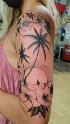 a woman's arm with flowers and palm trees on it