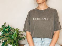 This simple and casual bridesmaid inspired t-shirt is the perfect bridal party gift.  Can even match outfits with the bride tribe on the bachelorette party by selecting the simple bride tee shirt. Give the gift of comfort, style and ease to the wonderful bridesmaids that are a big part of the wedding. *Black text is only available with the color shirt White, if selected.  Comfort Colors introduces its garment-dyed t-shirt. The soft-washed, garment-dyed fabric brings extra coziness to your wardro Custom Text Short Sleeve Tops For Wedding, Short Sleeve Tops For Bridesmaids, Cotton Crew Neck T-shirt For Hen Party, Bride Tee Shirts, Bride And Bridesmaid Shirts, Casual Bridesmaid, Bridesmaid Tshirts, Bridesmaid Shirt, Bride Tee