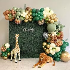 a giraffe and a lion are sitting in front of a fake grass backdrop